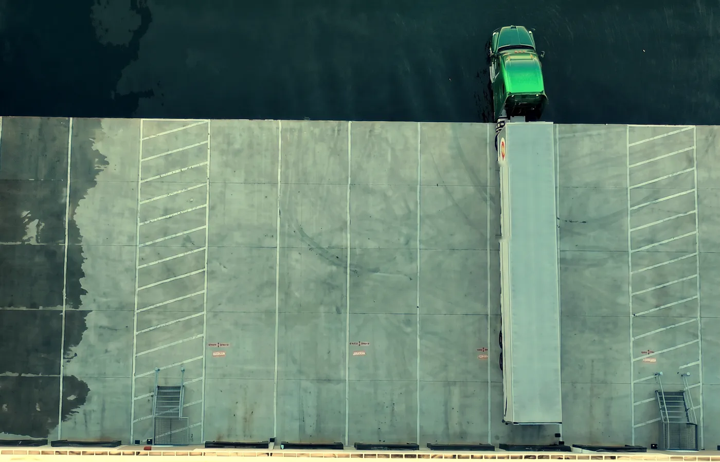 Aerial view of two Hermann green tractors loaded at the terminal docks